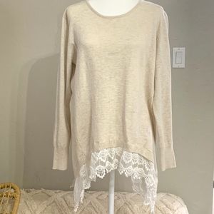 Long sleeve cream top with lace on the bottom.